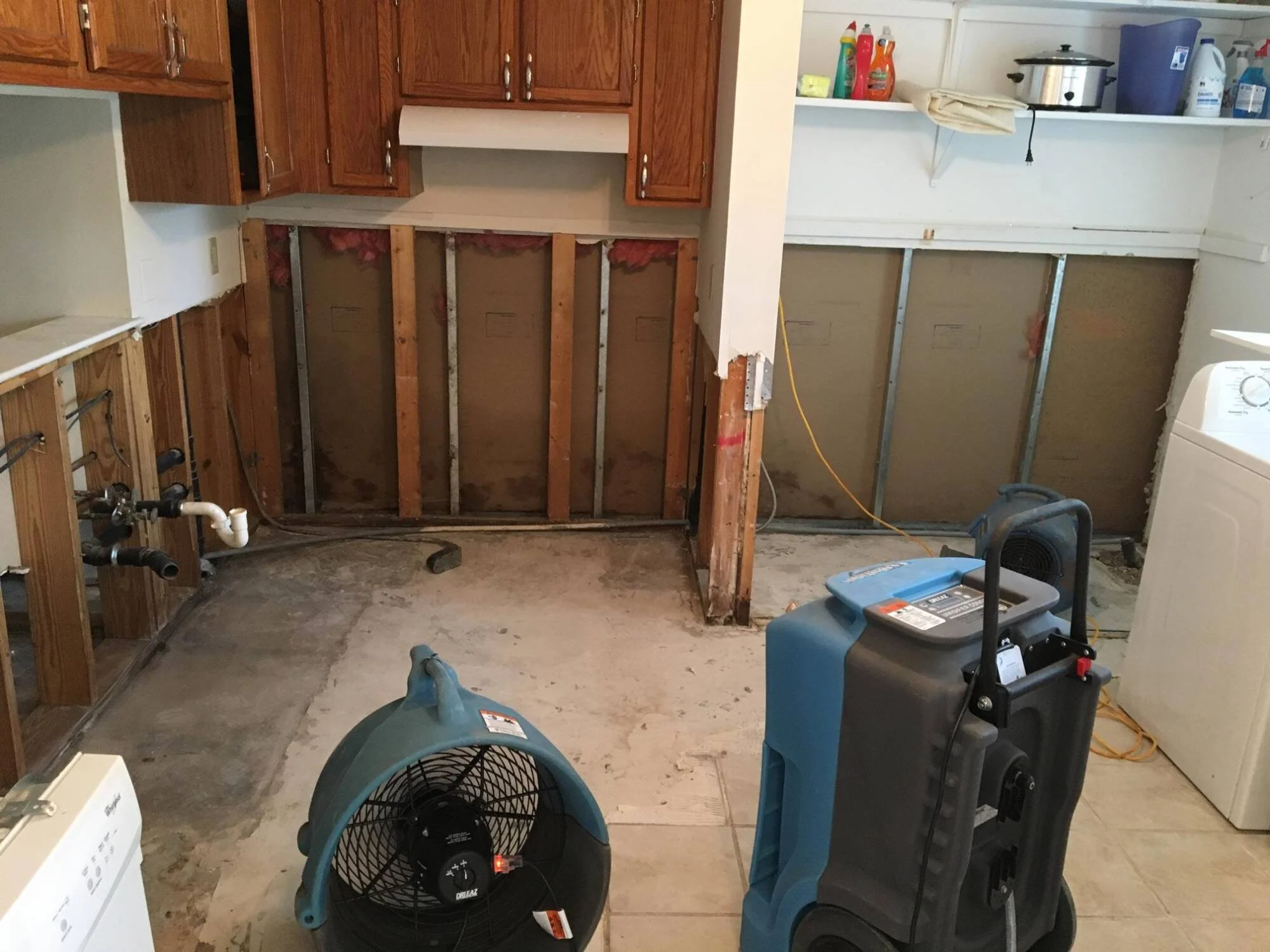 A water-damaged kitchen mid-restoration with CWDR drying equipment running